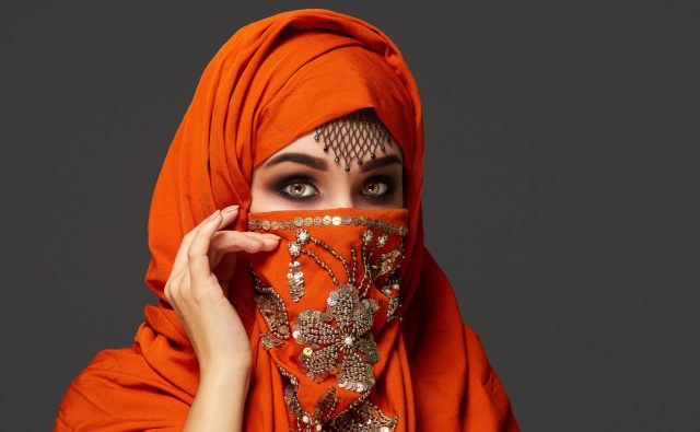 close-up-portrait-good-looking-young-woman-with-beautiful-smoky-eyes-fine-jewelry-forehead-wearing-terracotta-hijab-decorated-with-sequins-she-is-posing-sideways-looking-t
