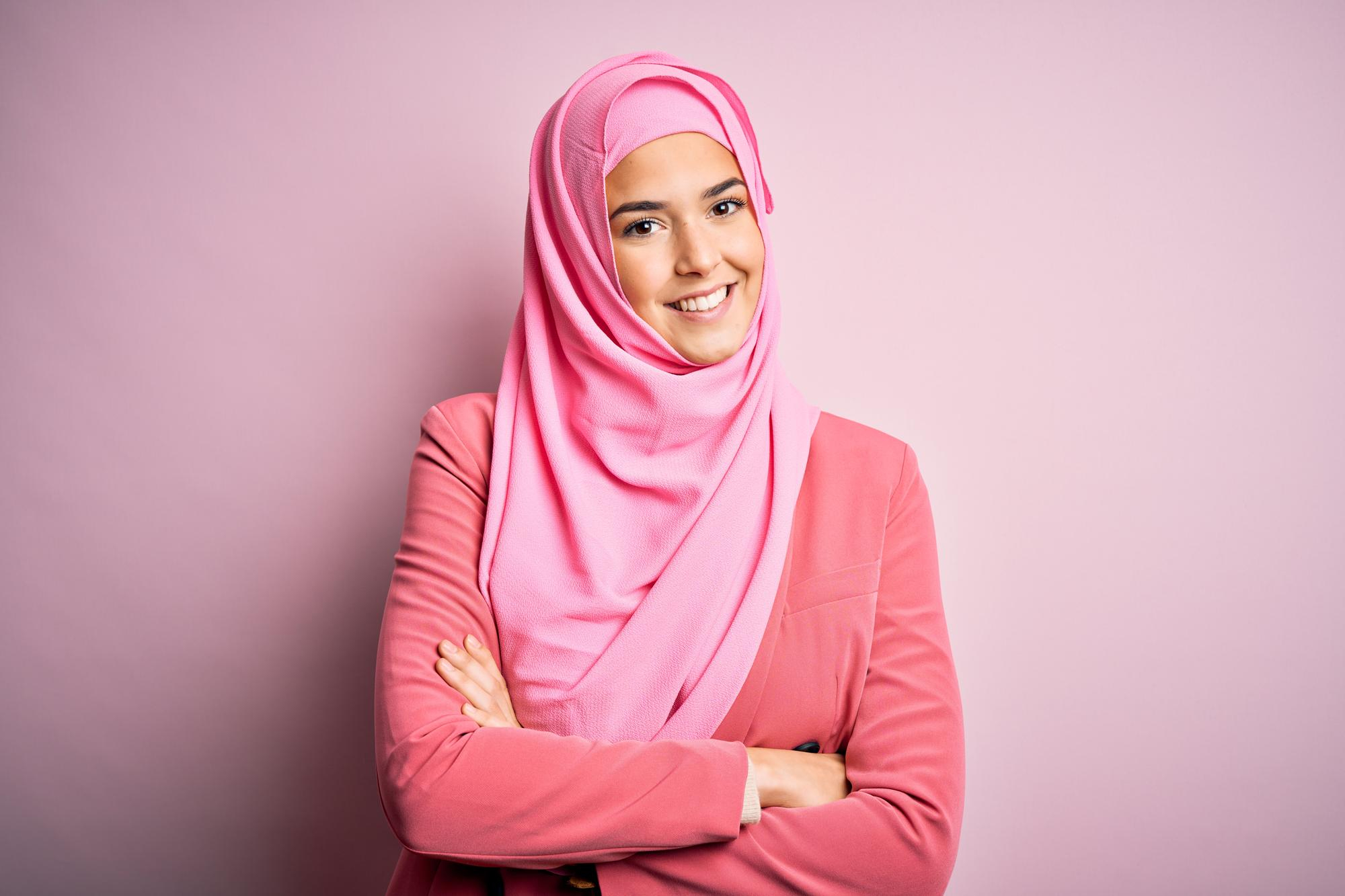 young-beautiful-girl-wearing-muslim-hijab-standing-isolated-pink-background-happy-face-smiling-with-crossed-arms-looking-camera-positive-person